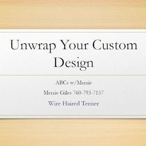 以下が含まれることがあります： セリフ体で「Unwrap Your Custom Design」と書かれた白い長方形の看板。その下に「ABCs w/Merrie」、電話番号、「Wire Haired Terrier」と書かれています。背景は明るい木目です。