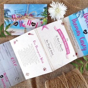 May include: A folded wedding invitation with a tropical theme. The front of the invitation features a beach scene with palm trees and the text "You are invited to the Wedding of Amelia and Thomas Casey". The back of the invitation includes details about the wedding ceremony and reception, as well as a honeymoon wish.