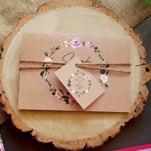Rustikale Hochzeitseinladungs-Conzertina mit rosa und weißen Blumen - Hochzeit lädt mit Tags, rustikaler Schnur und einer Auswahl an Umschlägen ein