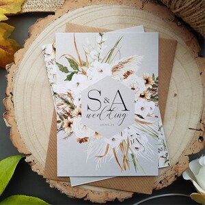 Boho wedding invitation set complete with envelopes. Boho floral in a wreath with bride and grooms name in centre with details of wedding on the back.