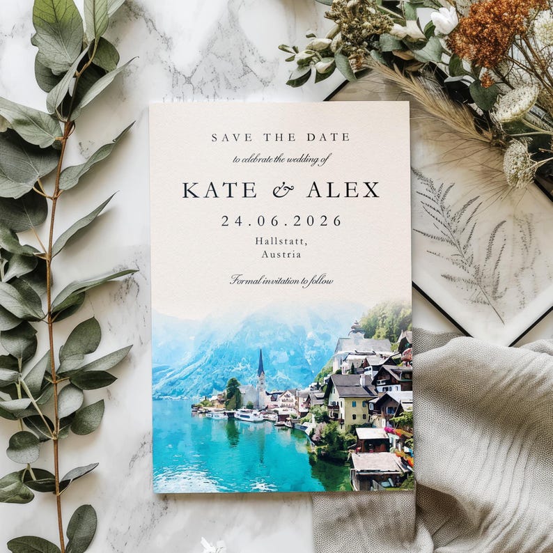 May include: A wedding invitation with the text "SAVE THE DATE" and the names "KATE & ALEX" along with the date "24.06.2026". The invitation features a scenic image of a lake and village with mountains in the background. The text "Hallstatt, Austria" is also included.