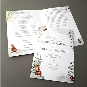 May include: Wedding stationery set with a watercolour design, featuring a fox, trees, and floral accents. The invitation includes the names Isabelle Simpson and Michael Roberts, with the date 14th December 2023. The set also includes an order of service.