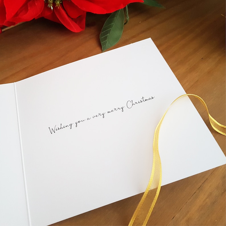 May include: A white card with the text "Wishing you a very merry Christmas" written in black cursive.