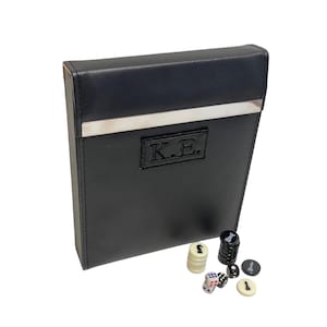 May include: Black leather case with a silver trim and the initials "K.E." embossed on the front. The case is open and contains a set of black and white game pieces and dice.
