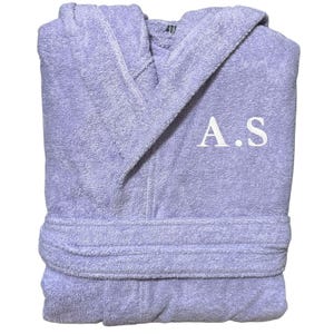 Peut inclure: Une robe de chambre à capuche lavande avec un monogramme brodé blanc "A.S."