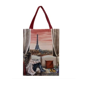 Könnte beinhalten: Eine Tragetasche mit einem Gemälde einer Frau, die in einem Raum mit Blick auf den Eiffelturm in Paris sitzt. Die Frau trägt ein weißes Hemd und Jeans. Auf dem Tisch vor ihr steht ein Tablett mit Essen und Champagnergläsern.