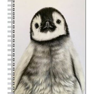 May include: A spiral-bound notebook featuring a detailed pencil drawing of a baby penguin. The penguin has a black head and back, with a white belly and chest. The notebook's pages are white, and the binding is silver.