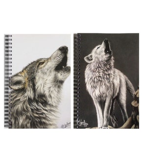 May include: Two spiral bound notebooks with a black and white wolf howling on each cover. The wolf on the left is gray and white, while the wolf on the right is white. Both wolves are drawn in a realistic style.