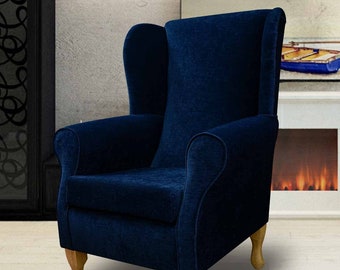 May include: A navy blue wingback armchair with wooden legs. The chair is upholstered in a soft, plush fabric.