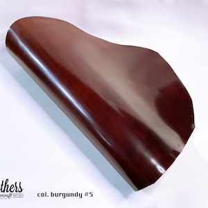 May include: A close-up of a burgundy leather sheet, rolled up and showing its smooth, glossy surface. The text "col. burgundy #5" is visible in the lower right corner.