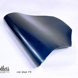 May include: A close-up of a dark blue leather sheet, folded in half, with a slight sheen. The leather is smooth and appears to be high quality. The text "col. blue #9" is visible in the lower right corner of the image.