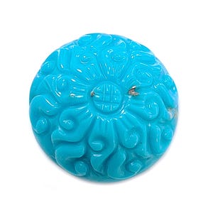 May include: A round, turquoise gemstone with detailed floral carvings. The gemstone is a vibrant blue-green colour and features a carved design. The gemstone is set against a white background.