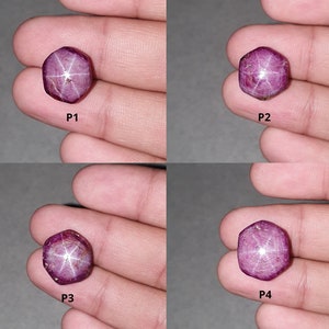 May include: Four star ruby gemstones in a variety of shapes and sizes. The gemstones are a deep red-purple color with a star-shaped pattern visible on the surface. Each gemstone is held in a hand.