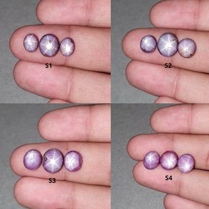 May include: Four sets of star ruby gemstones in varying arrangements. Each set is held in a hand and labeled S1 through S4. The gemstones are a purplish-pink color and display a star-like effect. The gemstones are oval and round.