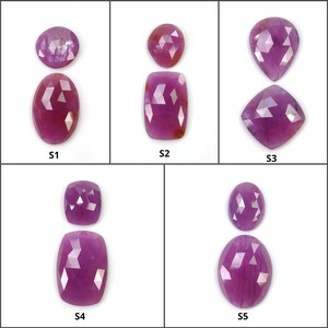 Puede incluir: Cinco pares de gemas facetadas, de formas variadas, incluyendo óvalos y cojines. Las gemas son de un color púrpura rosado intenso, con una superficie reflectante. Cada par se muestra sobre un fondo blanco, etiquetado S1 a S5.