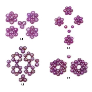 Puede incluir: Surtido de cabujones de rubí rosa en varios tamaños y arreglos. Los cabujones están dispuestos en forma de flores y etiquetados como L1, L2, L3 y L4.