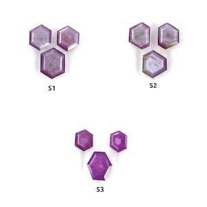Puede incluir: Tres juegos de cabujones de piedras preciosas púrpuras, cada juego etiquetado como S1, S2 y S3. Cada juego contiene tres cabujones hexagonales.