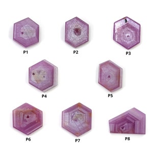 Puede incluir: Ocho gemas hexagonales de color rosa con un patrón en forma de estrella en su interior. Las gemas están etiquetadas de P1 a P8.