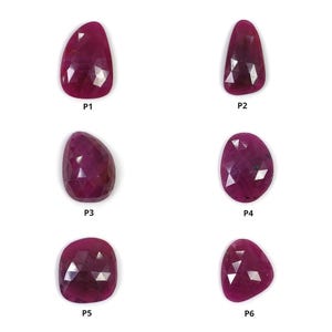 Peut inclure: Six pierres précieuses facettées de couleur magenta profond disposées en deux colonnes. Chaque pierre est étiquetée avec un code de P1 à P6. Les gemmes présentent un style taille rose avec de multiples facettes triangulaires.
