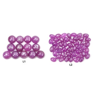 Puede incluir: Dos grupos de piedras preciosas se muestran sobre un fondo blanco. El primer grupo, etiquetado como "L1", presenta doce piedras preciosas redondas, pulidas, de color rosa intenso. El segundo grupo, etiquetado como "L2", muestra numerosas piedras preciosas ovaladas, pulidas, de color rosa intenso.