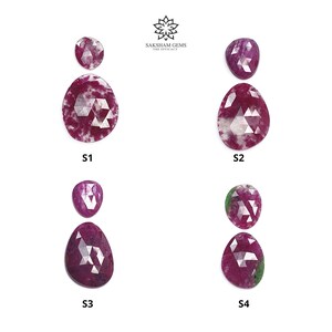 May include: Four pairs of faceted ruby gemstones, each with a smaller stone above a larger, teardrop-shaped stone. The rubies are a deep red with white inclusions. The image includes the text "SAKSHAM GEMS THE EFFICACY" and labels S1, S2, S3, and S4.