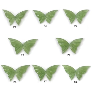 Könnte beinhalten: Acht grüne Jade-Schmetterlingscabochons, jeder mit einem einzigartigen Muster und einer einzigartigen Textur. Die Cabochons sind mit P1 bis P8 beschriftet.