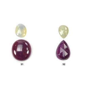 May include: Two ruby gemstones, one round and one pear-shaped, and two yellow gemstones, one round and one pear-shaped, on a white background. The round ruby is labeled "S1" and the pear-shaped ruby is labeled "S2".