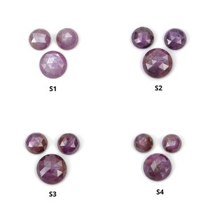 Puede incluir: Cuatro juegos de tres piedras preciosas de color púrpura facetadas, etiquetadas como S1, S2, S3 y S4.