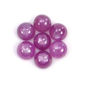 May include: Eight round, pink gemstones with a shiny, polished finish. The gemstones are arranged in a circular pattern.
