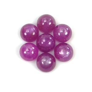 May include: Eight round, pink cabochon gemstones. The gemstones are arranged in a circle with the points facing outwards.