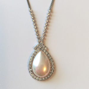 Teardrop Faux Pearl Pendant Necklace surrounded by Rhinestones that rise up the Chain in Lusterous Silver Tone Metal Chain