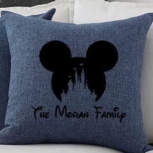 May include: Blue throw pillow with a black silhouette of Mickey Mouse ears and a castle inside. The text "The Moran Family" is printed below the silhouette.