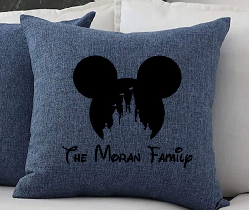 May include: Blue throw pillow with a black silhouette of Mickey Mouse ears and a castle inside. The text "The Moran Family" is printed below the silhouette.