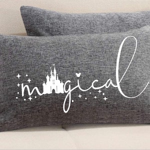 May include: Two gray pillowcases with a white silhouette of a castle and the word "magical" with stars around it.