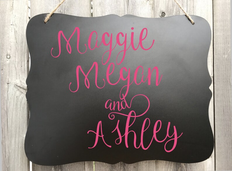 Puede incluir: Se&ntilde;al negra de pizarra con una inscripci&oacute;n cursiva rosa que dice "Maggie Megan y Ashley".