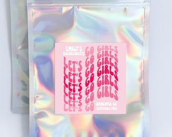 May include: A silver iridescent zippered pouch with a pink sticker that says "Emily's Bachelorette Go Girls Let's Go" with a pink and white repeating pattern of "Go Girls Let's Go" in a retro font.  The sticker also says "Bachelorette Kit September 2023".