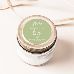 May include: A glass jar with a green and white label that says "jam packed with love Bailey + Zachary 05.06.2023".