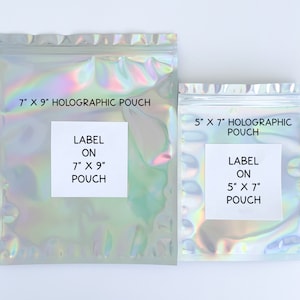 May include: Two iridescent holographic pouches with white labels. The larger pouch is 7 inches by 9 inches and the smaller pouch is 5 inches by 7 inches. Both pouches have labels that say "LABEL ON" and the size of the pouch.