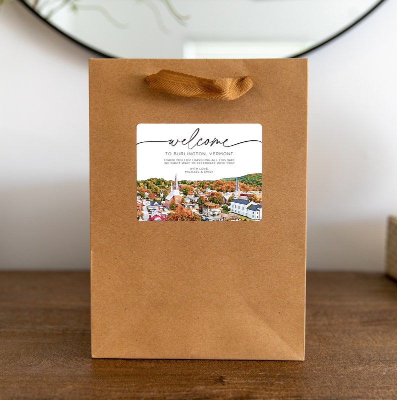 May include: A welcome sign with a photo of a town in Vermont. The sign says "Welcome to Burlington, Vermont. Thank you for traveling all this way. We can't wait to celebrate with you. With love, Michael & Emily."