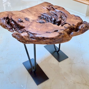 May include: A rustic wooden coffee table with a live edge top and black hairpin legs.