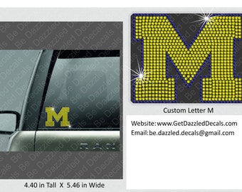 May include: A yellow letter M made of rhinestones on a blue background. The letter is 4.40 inches tall and 5.46 inches wide. The text "Custom Letter M" is below the letter. The website and email address for the seller are below the text.