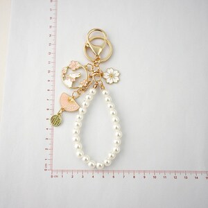 Porte-clés en ruban rose - Joli porte-clés avec pendentif perle - breloques pour sacs à main suspension - chaîne d'étuis AirPods - chaîne d'étuis pour téléphone - porte-clés