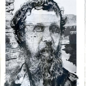 May include: Black and white photograph of a man with a beard. The man is looking at the camera. The photograph is a collage with a landscape image of a canyon in the background.