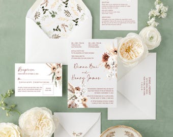 May include: Elegant wedding invitation suite featuring a floral design in neutral tones. The set includes invitations, response cards, details cards, and envelopes. The invitation text includes the names Diane Bui and Henry James, along with wedding details. The suite is arranged with white flowers and a decorative plate.