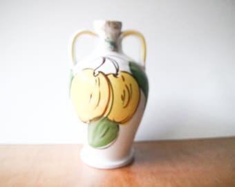 Vintage amphora-shaped ceramic bottle with lemon decoration contained amaro from Etna volcano