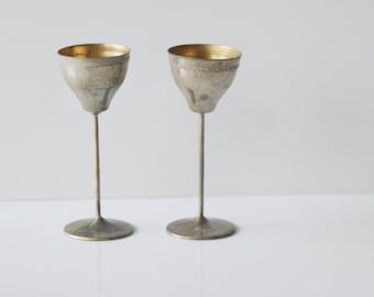 Two mini metal glasses with different incisions on the edge