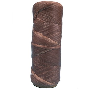 May include: A brown, tightly wound roll of raffia ribbon. The raffia is a natural fiber, and the roll is about 6 inches long.