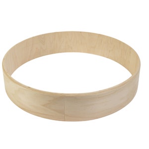 May include: A natural wood drum hoop, a circular wooden ring used for making drums. The hoop is made of light-colored wood and has a smooth, polished finish.