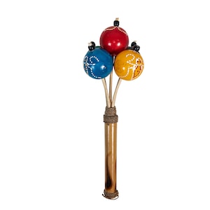 May include: A wooden musical instrument with three colorful balls attached to the end of a stick. The balls are blue, red, and yellow and have white designs on them.