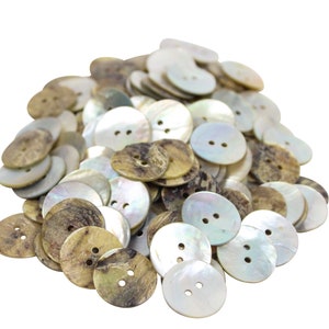May include: A pile of round, white and brown shell buttons with two holes each. The buttons are made of natural materials and have a rustic, organic look.
